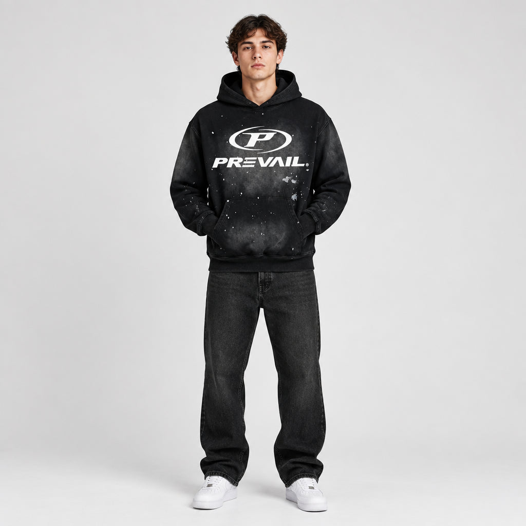 A black pullover hoodie with a white distressed graphic on the front featuring the 'P' logo and the word 'PREVAIL'. The hoodie has a faded, washed-out starry pattern on the sleeves and body, and is displayed against a solid white background.